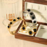 Bracelet jonc en or avec cinq pierres noires naturelles, design contemporain élégant.