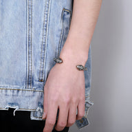 Bracelet jonc argent en acier inoxydable avec double têtes de serpent sculptées, style moderne.