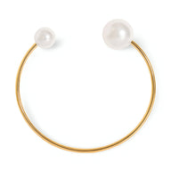 Bracelet jonc fin en titane plaqué or 18 carats, perles blanches d'imitation aux extrémités, design élégant et minimaliste.