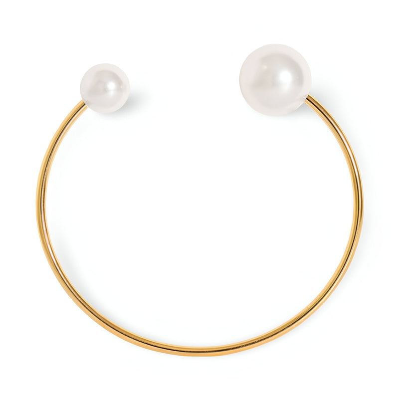 Bracelet jonc fin en titane plaqué or 18 carats, perles blanches d'imitation aux extrémités, design élégant et minimaliste.