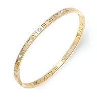 Bracelet jonc fin plaqué or avec chiffres romains gravés et trois pierres de zircon scintillantes.