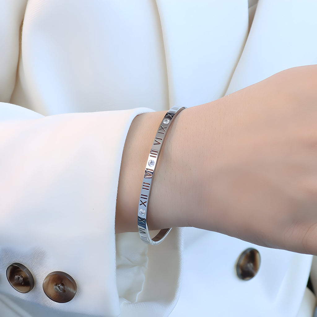 Bracelet jonc en titane argenté avec chiffres romains gravés et pierres de zircon délicates.