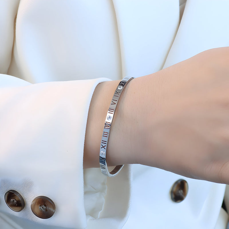 Bracelet jonc en titane argenté avec chiffres romains gravés et pierres de zircon délicates.