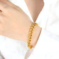 Bracelet maille cubaine en titane plaqué or brillant porté au poignet femme.