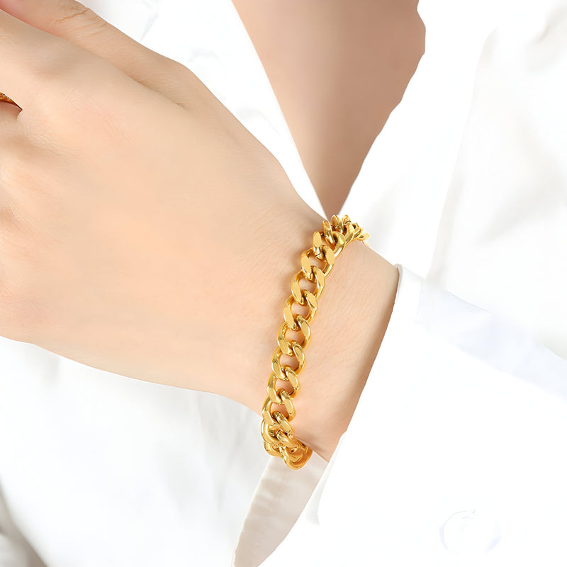Bracelet maille cubaine en titane plaqué or brillant porté au poignet femme.