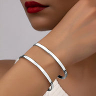 Bracelet manchette double rang en argent lisse et brillant porté au poignet féminin.