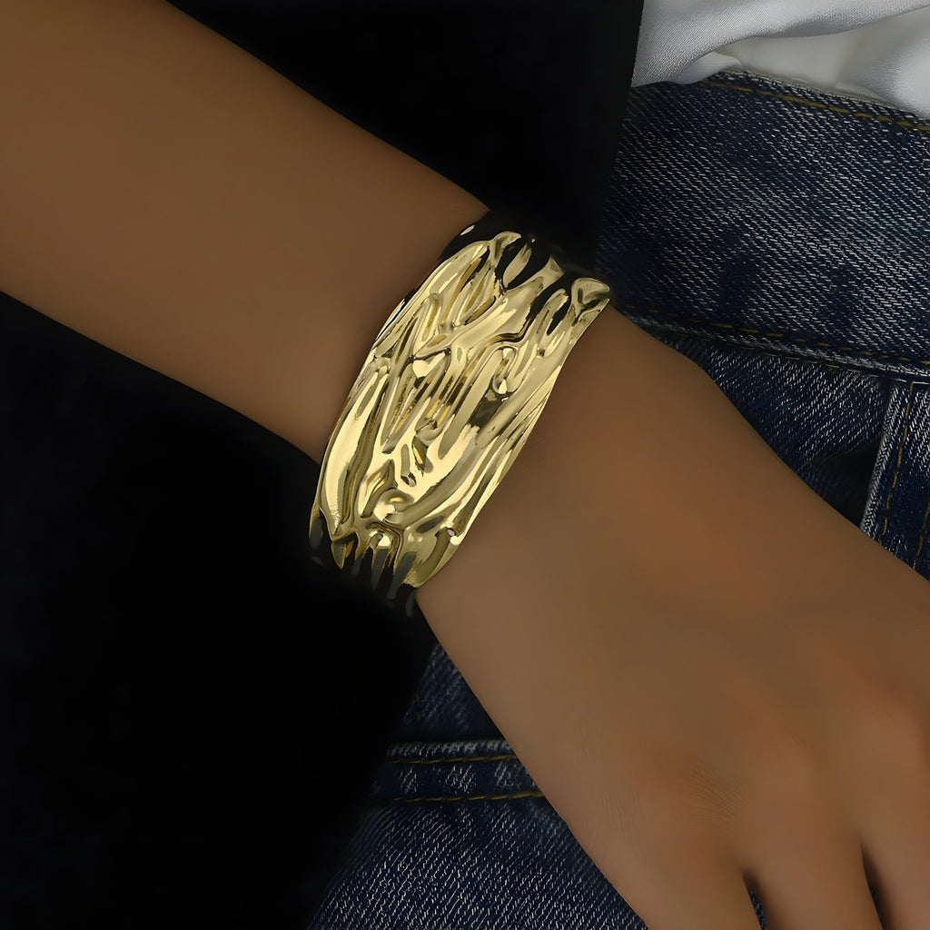 Bracelet manchette en or jaune avec surface texturée ondulée et finition brillante.