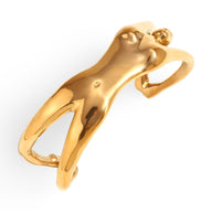 Bracelet manchette doré en forme de buste de femme stylisé, finition brillante.