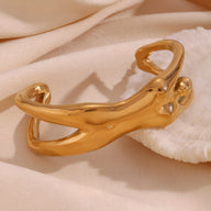 Bracelet manchette doré en forme de buste féminin stylisé avec finition lisse et brillante.