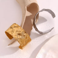 Bracelet manchette ondulé en acier inoxydable doré avec texture martelée élégante.