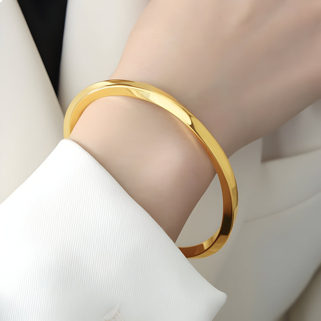 Bracelet rigide en titane plaqué or brillant au design simple et élégant pour femme.
