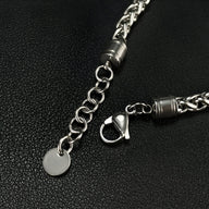 Bracelet homme chaîne argentée avec fermoir mousqueton et pendentif rond lisse en acier.