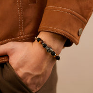 Bracelet homme perles œil de tigre marron et tête de mort métal noir élégant.