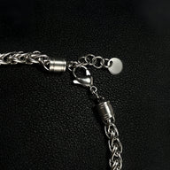 Bracelet homme en acier avec maillons tressés et fermoir mousqueton, finition argentée.