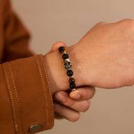 Bracelet homme perles noires et marron avec tête de mort argentée et pierre œil de tigre.