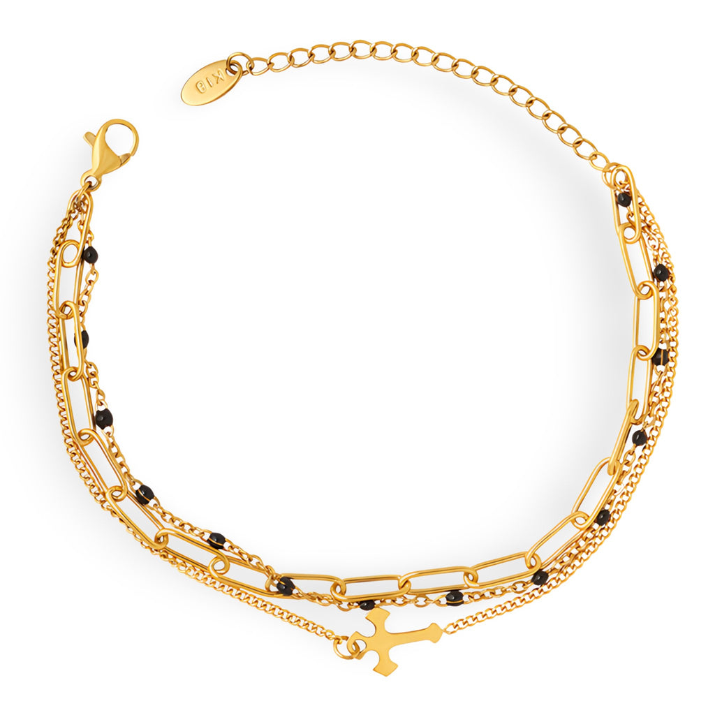 Bracelet triple rang en titane plaqué or avec motif croix et petites perles noires.