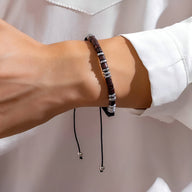 Bracelet en perles de bois marron avec détails argentés et cordon noir ajustable, style masculin élégant.