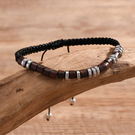 Bracelet homme en perles bois carré marron et noir avec éléments métalliques argentés sur cordelette noire tressée.