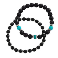 Ensemble de deux bracelets pour homme en pierres volcaniques noires, détail perles turquoise et anneaux métalliques argentés.