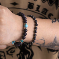 Ensemble de deux bracelets pour homme en pierres volcaniques noires avec perles turquoise et détails argentés.